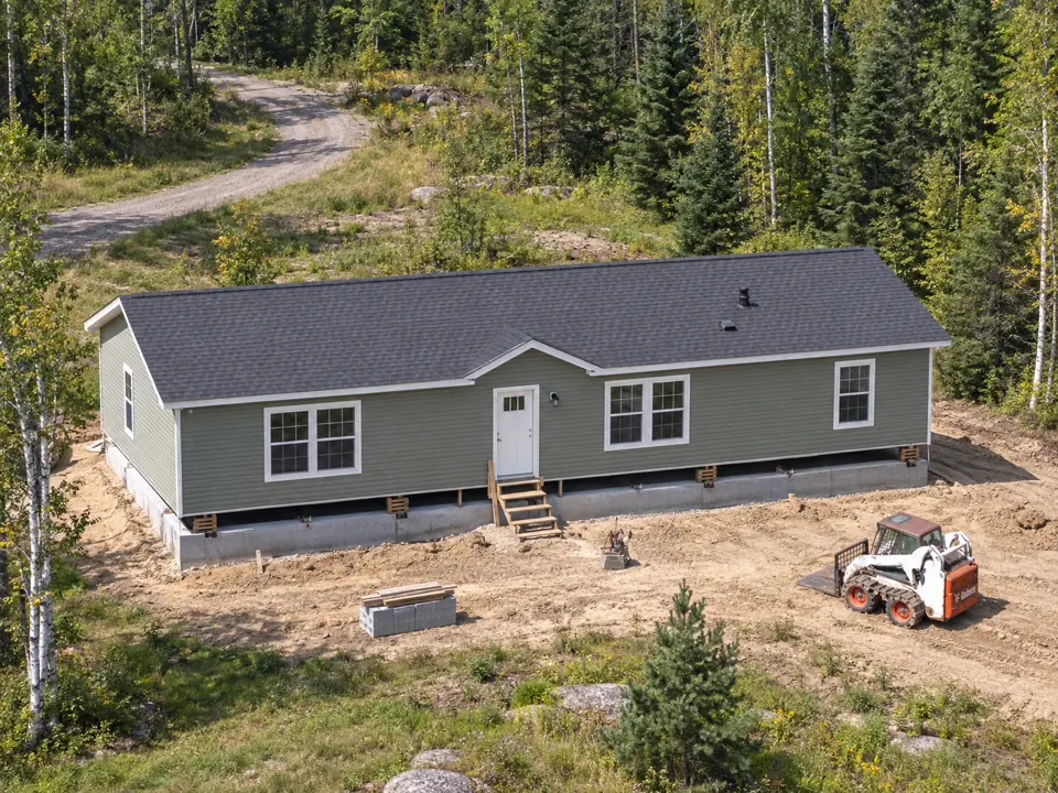 Manufactured home at a wooded site before skirting is installed